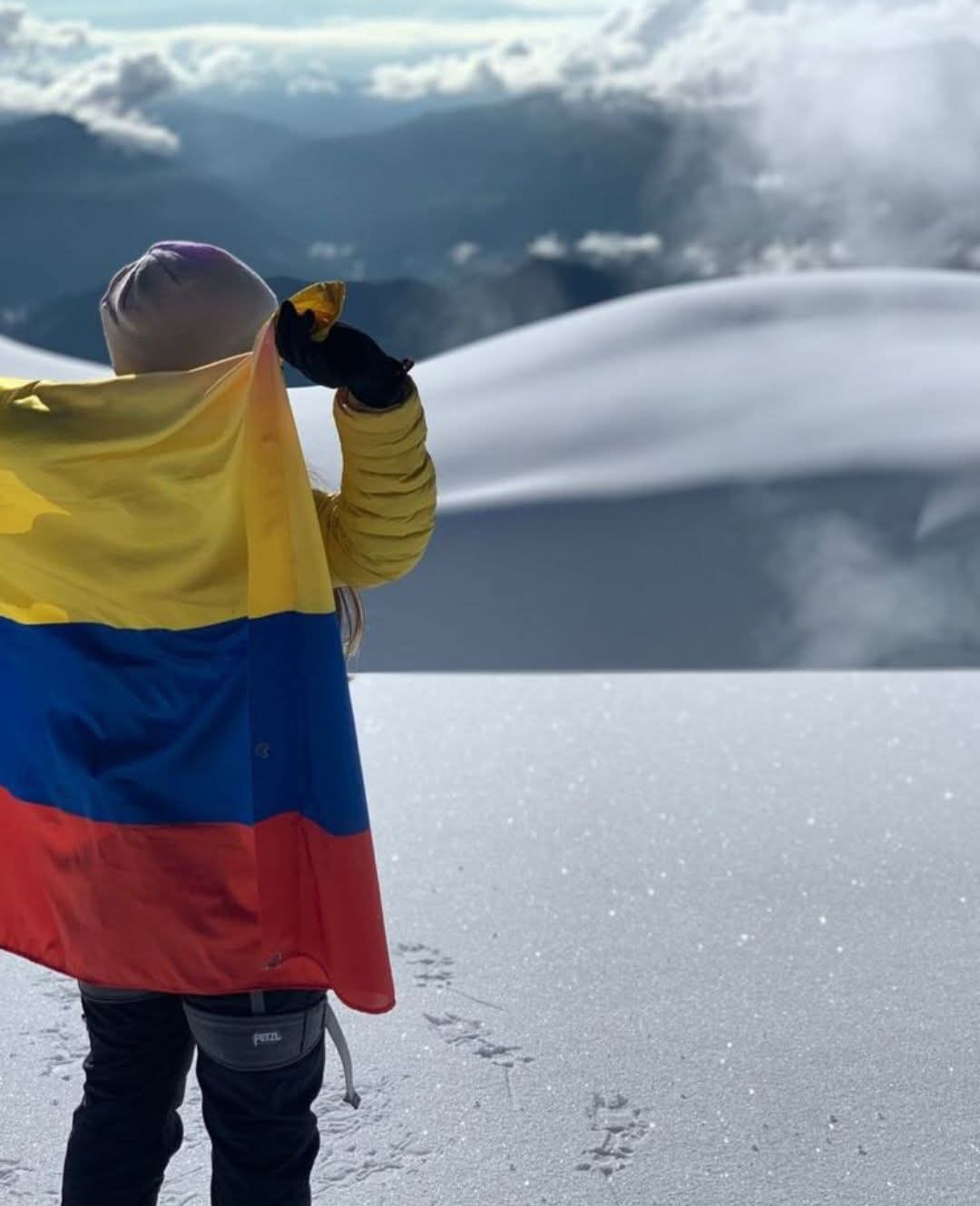 Alpinista con bandera en Nevado del Ruiz